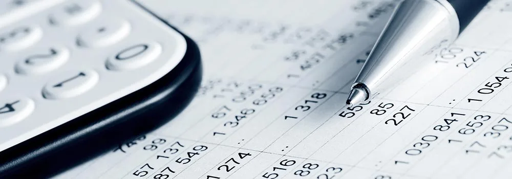 Contractor checking payroll numbers with a calculator to catch underpayments early