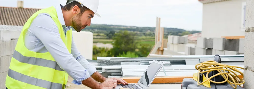 Contractor pulling up the books on a laptop right at the jobsite