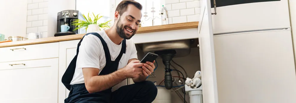 Plumber checking job numbers on his phone between service calls