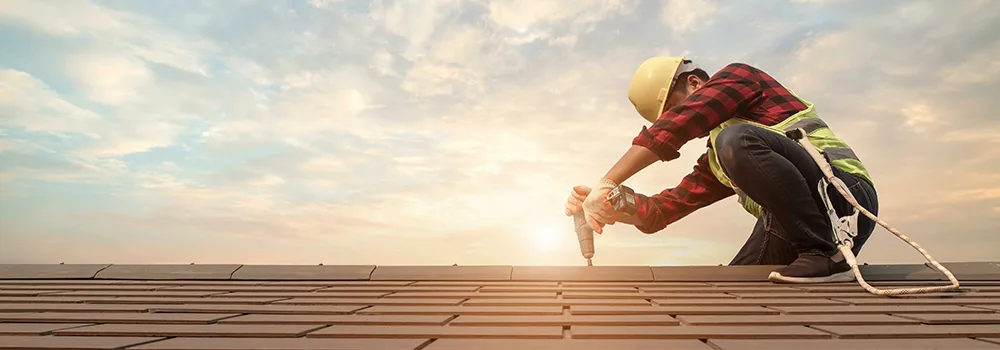 Roofer up on the roof where pitch and square footage drive the estimate