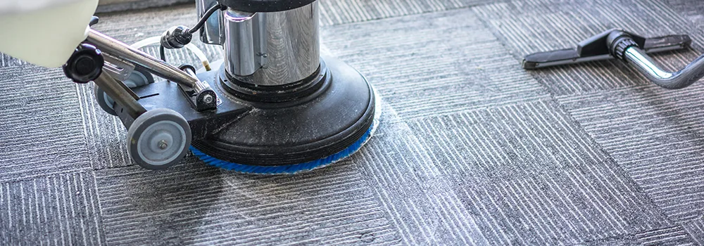 A commercial carpet cleaning machine working across office carpet tiles