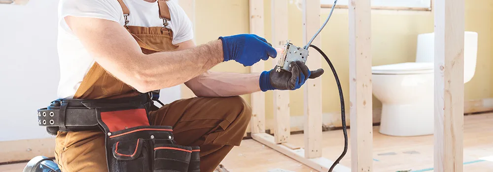 An independent electrician testing a panel, the kind of contractor whose payments can add up to a 1099 by year-end