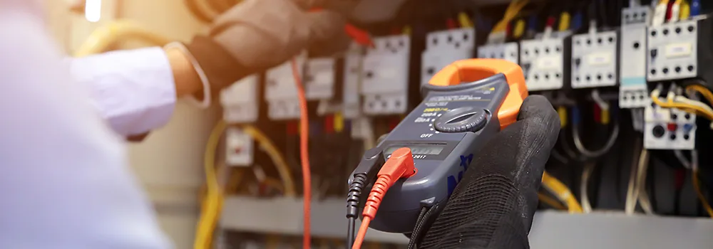 An electrician at the truck before the first task, clocking in from a phone instead of a paper timesheet